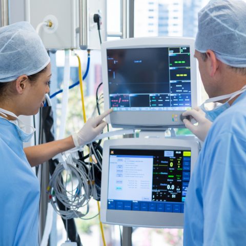 Surgeons reading computer screen in operation theater